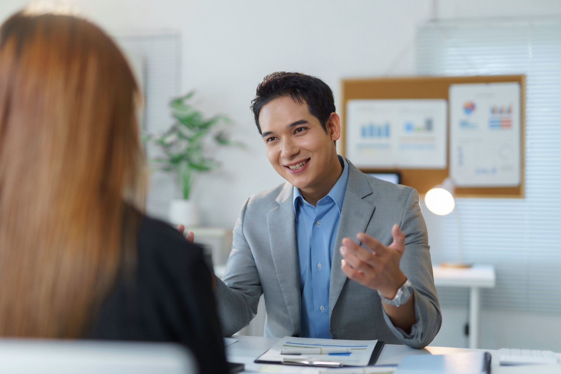 Young businessman engaging in a discussion with a colleague during a meeting in the office, fostering teamwork and collaboration